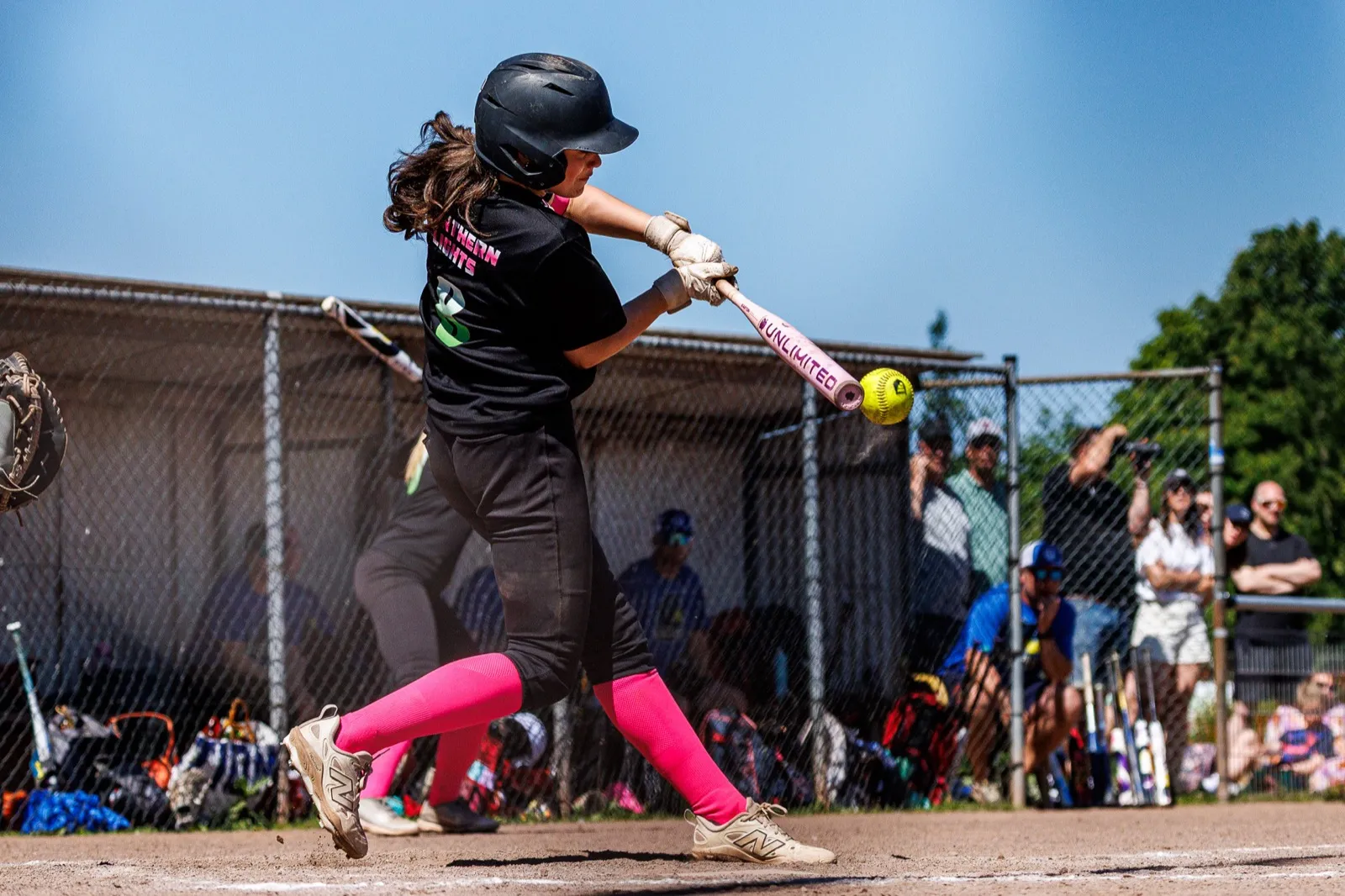 Een softbalspeelster raakt de bal tijdens het NK Little League 2026.