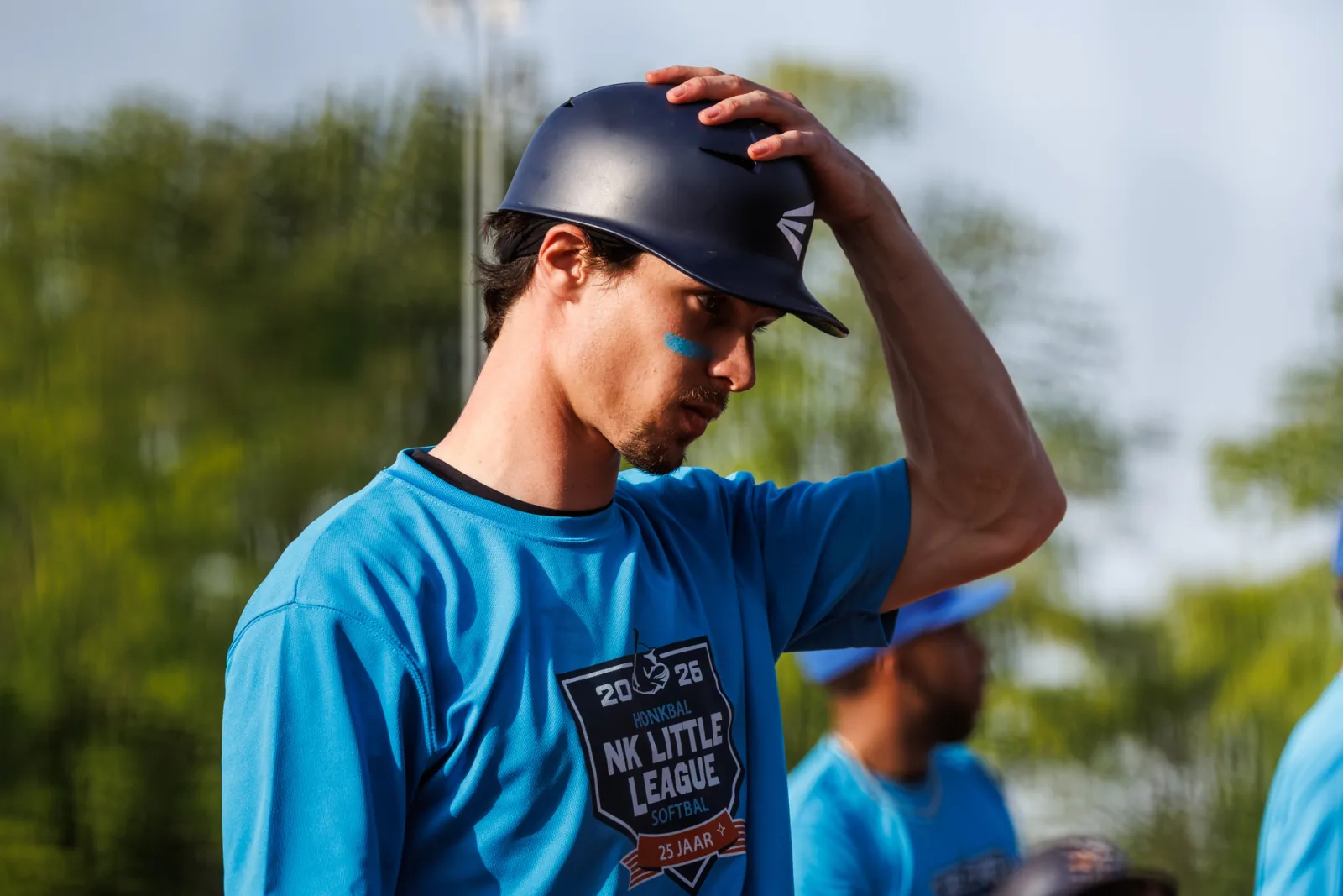 Speler in het lichtblauwe NK Little League-shirt zet zijn helm af.