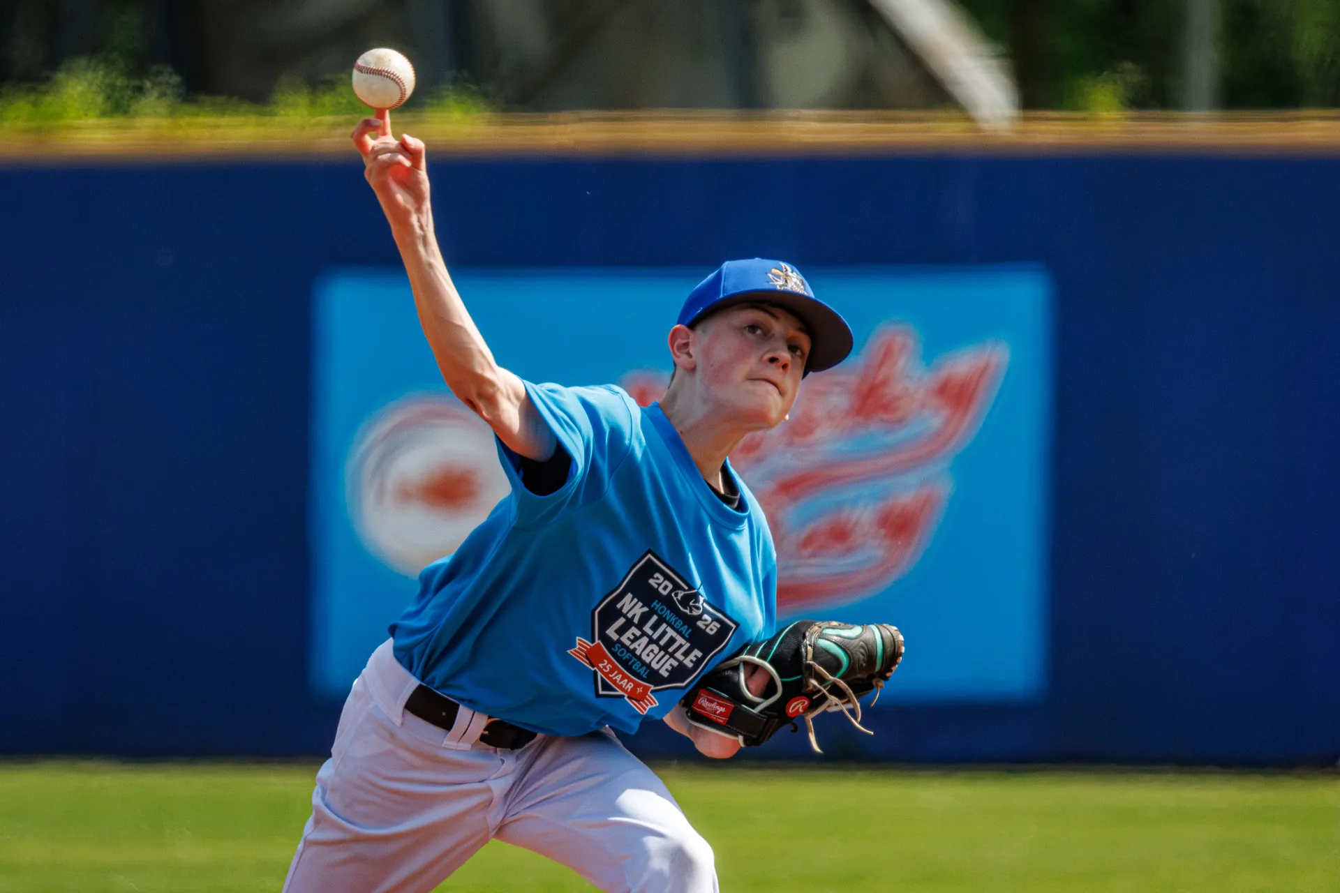 Pitcher in het lichtblauwe NK Little League-shirt haalt uit voor de worp