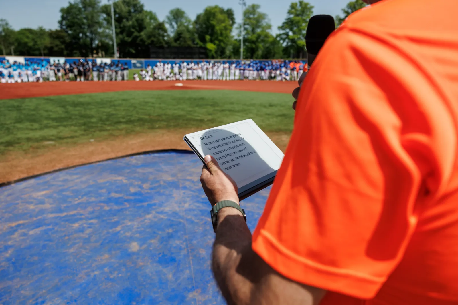 Iemand slaat het regelboek open naast de werpheuvel.